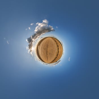 A small planet with a blue sky and clouds photo