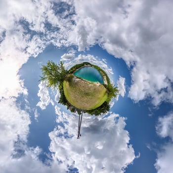 A small planet with a blue sky and clouds photo