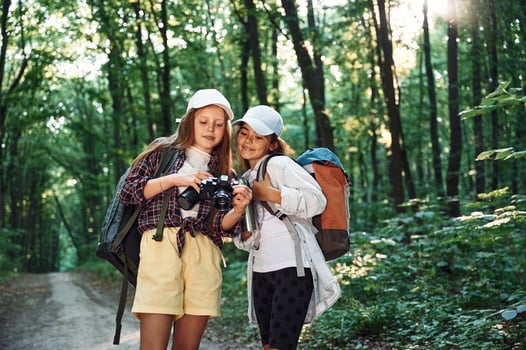Standing on the footpath,. Two girls is in the forest having a leisure activity, discovering new places photo