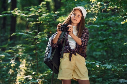 Girl is in the forest at summer day time discovering new places photo