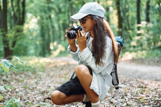 Using professional camera.. Girl ,is in the forest at summer day time discovering new places photo