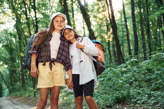 Front view. .Two girls is in the forest having a leisure activity, discovering new places photo
