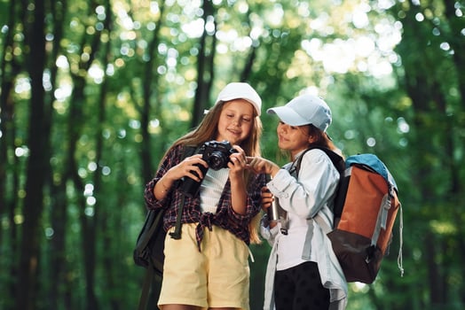 Front view of two girls that is in the forest ,having a leisure activity photo