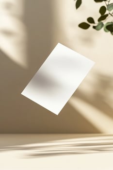 A blank business card hovers in midair, casting a gentle shadow below. The background is a smooth gradient with soft focus, emphasizing a sleek and modern aesthetic ideal for branding photo