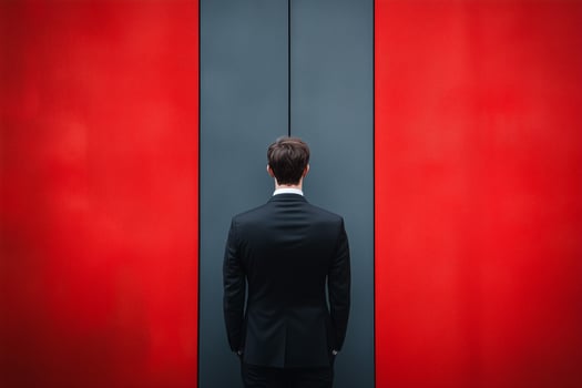 Man in a suit against a red and gray wall photo