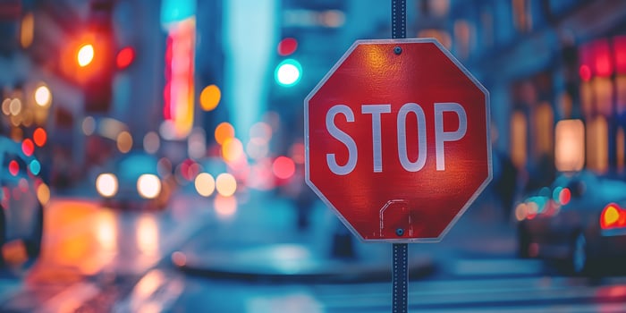 A striking close-up of a stop sign amidst a bustling urban setting, capturing the vibrant glow of city lights and traffic. photo