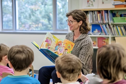 Smiling teacher reading a story to her preschool students photo