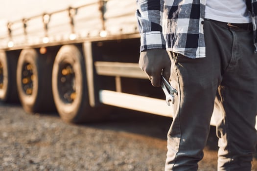 Close up view.. Young truck driver is with his vehicle at daytime photo