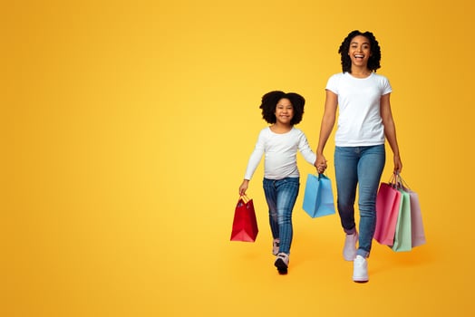 Happy Black Mother And Daughter Walking With Many Bright Shopper Bags Over Pink Background photo