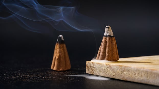 Burned incense cones for aromatherapy isolated on black background photo