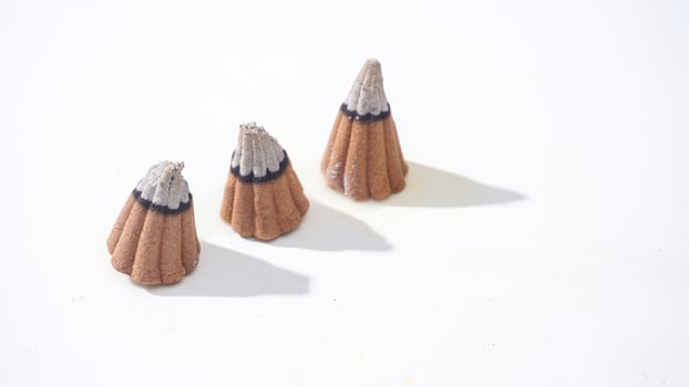 Three burned aroma incense cones isolated white background photo