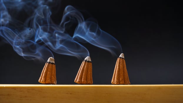 Burned incense cones for aromatherapy with smoke isolated on black background photo