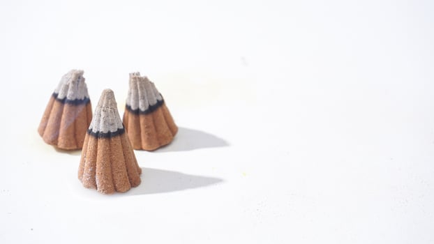 Three burned incense aroma cones isolated white background photo