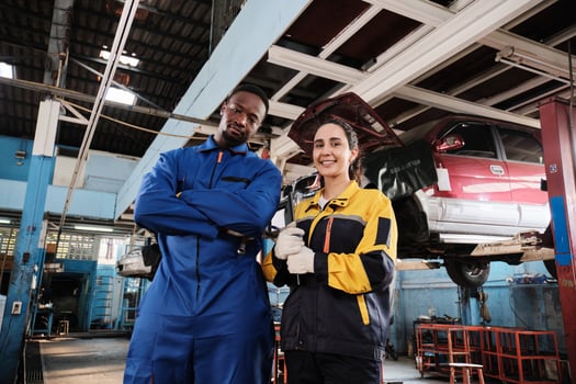 Happy professional teamwork, cheerful Latin female inspector engineer and Black mechanic smile and look at camera in fix car garage, maintenance service jobs in automotive transport industry. photo