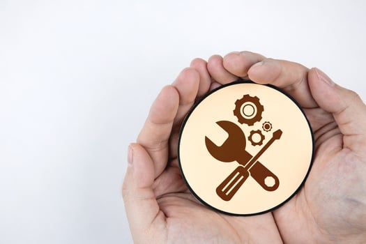 Hand holding paper with gear icon and mechanic tools. Concept of maintenance, process of maintaining and repairing equipment or systems to work efficiently. photo