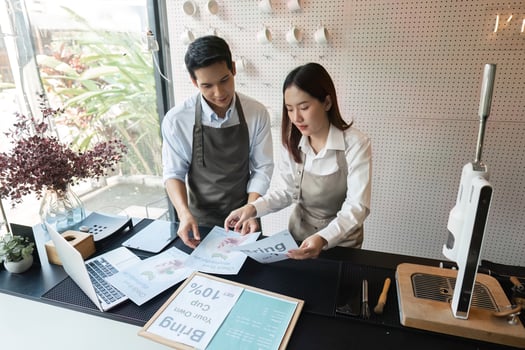 Creative Collaboration. Two baristas reviewing promotional materials and planning for a successful coffee shop campaign together. photo