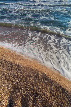 Wave crashing on the beach, with water and sand in motion photo