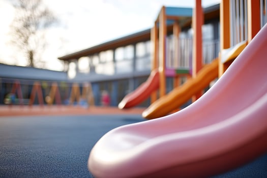 Bright slides and swings invite children to play in a lively playground. In the background, kids can be seen enjoying themselves under a clear sky, creating a joyful atmosphere photo