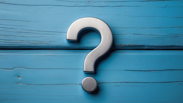 Metal question mark on blue wooden background photo