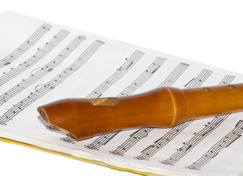 Recorder on a sheet music over white photo