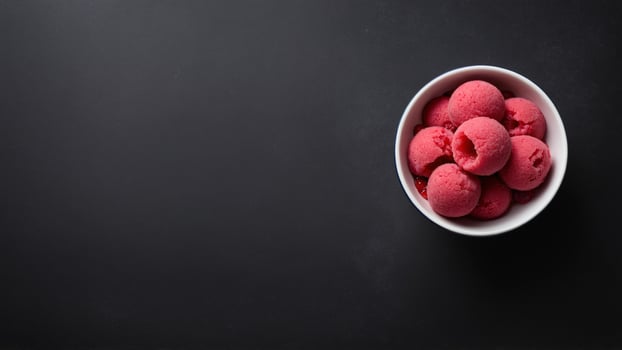 Bowl of raspberry ice cream on black background photo