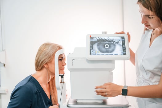 Side view. .Woman's vision is tested by clinic worker that using special device photo