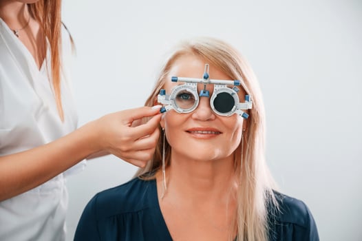 Wearing glasses. Woman's vision is tested by clinic worker that using special device. photo