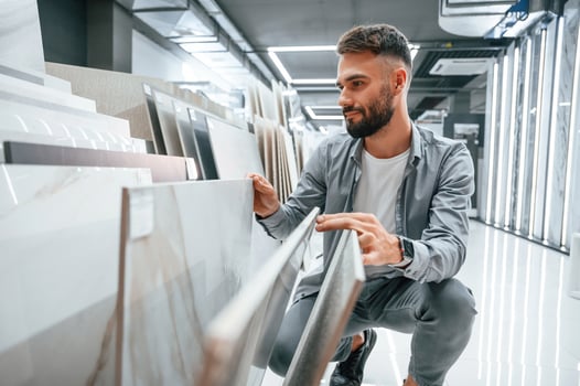 Choosing the plate. Stylish beautiul man is in the store of goods for the home photo