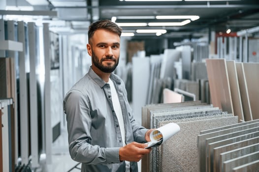 Standing with notepad in hands. Stylish beautiul man is in the store of goods for the home photo