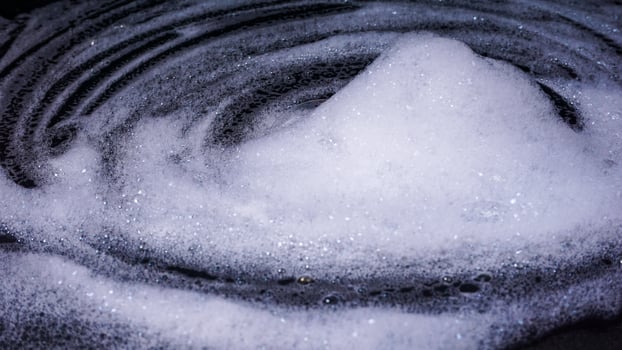 Close up of white foam bubbles isolated on black background photo
