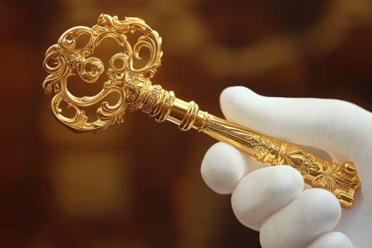 A gloved hand displays an ornate golden key photo