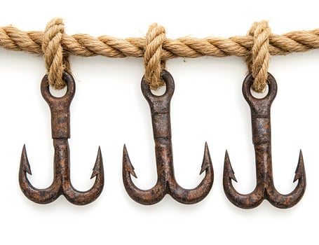 Three Rusty Double Hooks Hang From Rope photo
