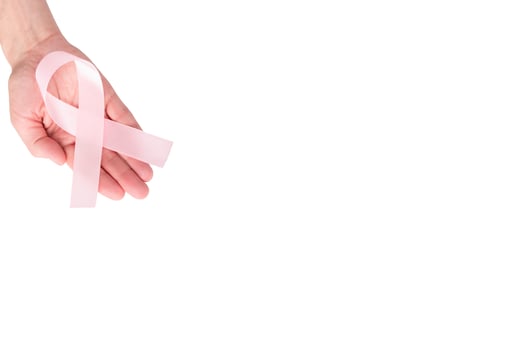 Pink satin ribbon on the palm of a woman, isolated on a white background. Cancer awareness symbol, women's health, breast cancer. copy space photo
