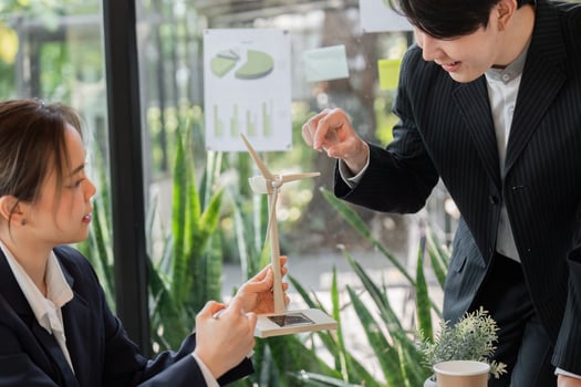 Sustainability and Renewable Energy. Professionals discussing a wind turbine model, exploring renewable energy solutions for a greener future. photo