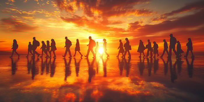 Silhouetted figures walking at sunset, creating a serene and reflective atmosphere with vibrant colors. photo