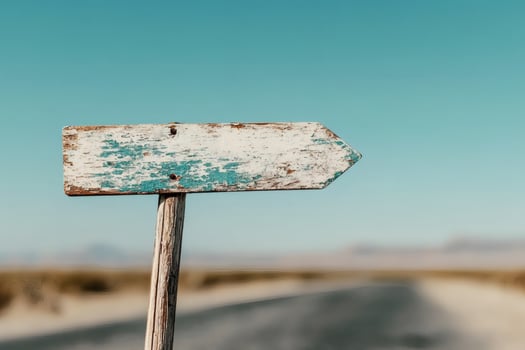 Rustic wooden signpost along a tranquil desert road. photo