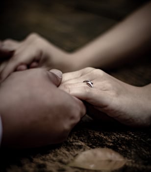 Couple holding hands with an engagement ring photo