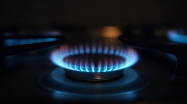 Blue flames on a gas stove burner in the dark photo