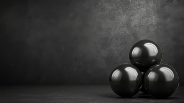 Three glossy black spheres stacked on a dark surface photo