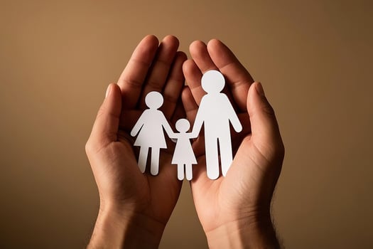 Supporting Hands Cradling A Paper Family Cutout Representing Love And Protection photo