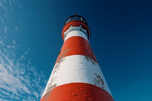 Vibrant lighthouse standing tall against the deep blue sky. photo