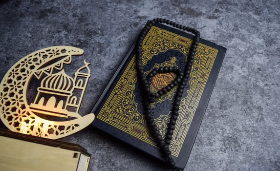 The holy quran, golden ramadhan lamp with islamic rosary beads on dark background ramadhan. Islamic concept photo