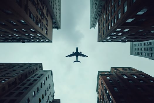 Airplane flying over city buildings in urban area photo