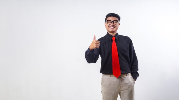 Happy Asian man wearing formal clothes shows thumb up isolated on white background photo