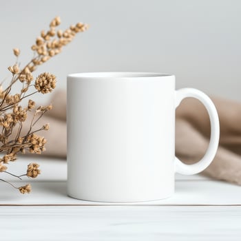blank white mug on wooden table with dried flowers, perfect for customization or as minimalist decor piece photo