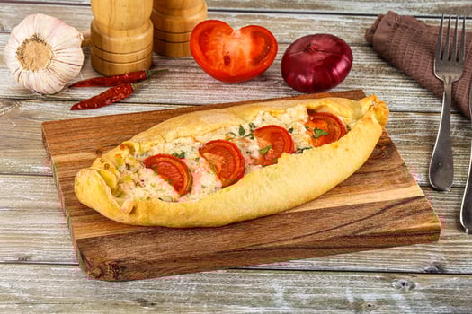 A bread roll with tomatoes and cheese on it photo