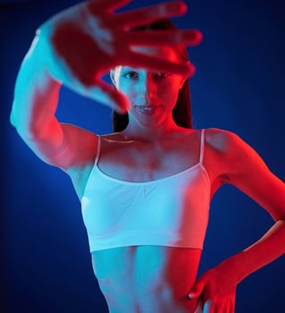 Doing, gestures ,by the hands. .Young woman in underwear is in the studio with neon lights photo