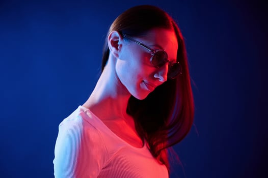 Standing ,and posing. Portrait ,of young woman that is indoors in neon lighting photo