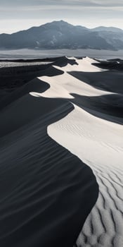 A desert landscape with sand dunes and mountains photo