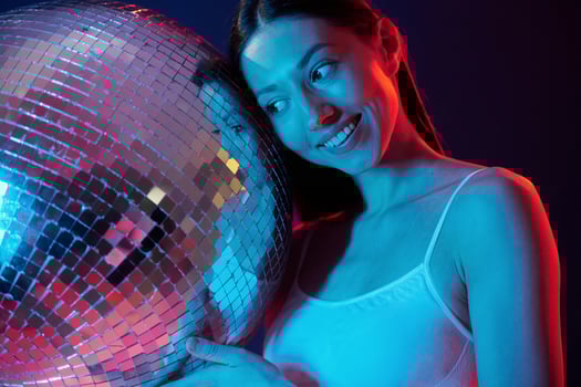 Party time. Holding mirrored ball. .Young woman in underwear is in the studio with neon lights. photo